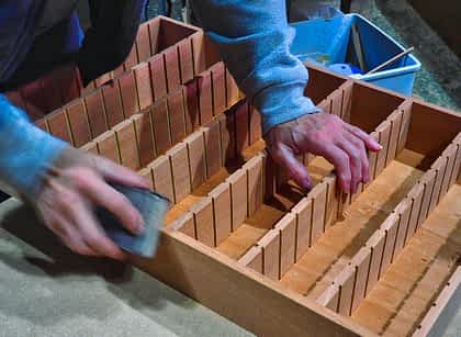 Sanding a Spanish cedar tray by hand at Wacota